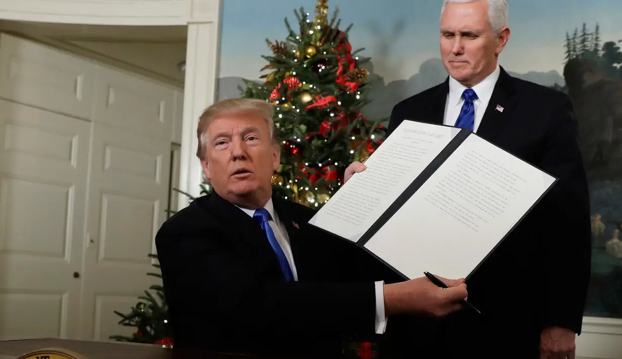 Presiden AS Donald Trump didampingi wakilnya Mike Pence, menunjukkan dokumen pengumuman Yerusalem yang akan ditandatangani di Ruang Penerimaan Diplomatik Gedung Putih, Washington, Rabu (6/12). (AP Photo / Evan Vucci)