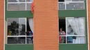 Orang-orang menggantungkan kain merah di rumah mereka untuk meminta bantuan makanan selama lockdown di kotamadya Soacha, dekat Bogota, 4 April 2020. Presiden Kolombia Ivan Duque menetapkan lockdown dari 24 Maret hingga 13 April sebagai langkah mencegah penyebaran virus corona. (Raul ARBOLEDA/AFP)