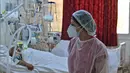 Seorang petugas medis Tunisia merawat pasien di gym yang diubah untuk menangani lonjakan infeksi COVID-19 di pusat kota Kairouan pada 4 Juli 2021. Tunisia tengah berjuang menghadapi tsunami COVID-19 sementara jumlah orang yang meninggal akibat virus corona terus melonjak tinggi. (FETHI BELAID/AFP)