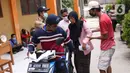 Warga membantu seorang nenek usai mengambil bantuan sosial (bansos) yang diberikan Pemerintah Provinsi Banten di Pinang, Tangerang, Jumat (1/5/2020). Bansos berupa uang tunai sebesar Rp 600 ribu tersebut diberikan kepada warga yang terdampak virus corona COVID-19. (Liputan6.com/Angga Yuniar)