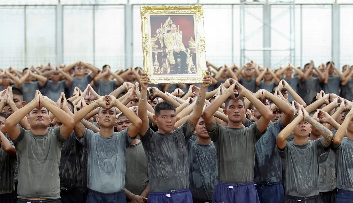Narapidana berbaris memberi penghormatan untuk mendiang Raja Thailand Bhumibol Adulyadej di penjara Pathum Thani, Bangkok, Thailand (27/10). Pemerintah Thailand menyatakan masa berkabung untuk Raja Bhumibol selama 1 tahun. (Reuters/Chaiwat Subprasom)