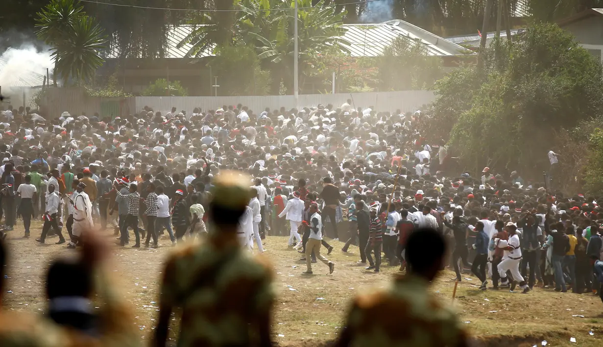 Demonstran mulai berlari saat gas air mata dilepaskan polisi di kota Bishoftu, Ethiopia, Ahad (02/10). Pemerintah Ethiopia menyatakan 52 orang tewas dan banyak lainnya terluka. (REUTERS/Tiksa Negeri) 