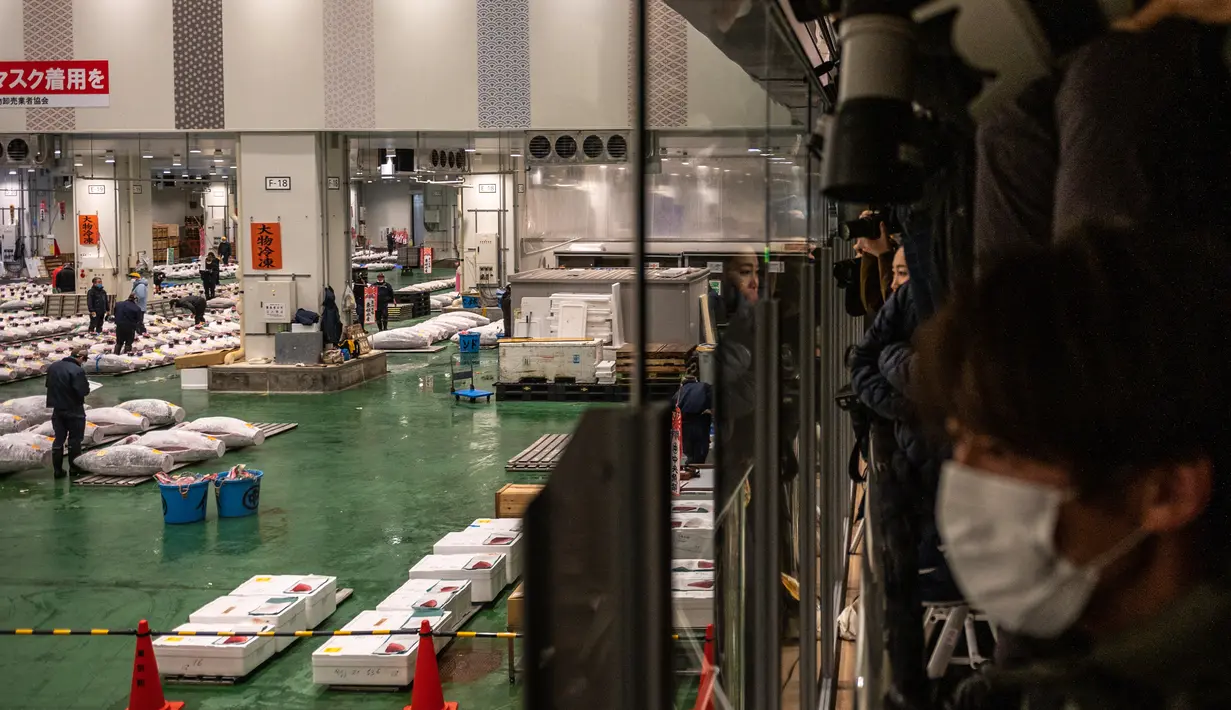 Jurnalis memfilmkan dan mengambil gambar dalam lelang tuna Tahun Baru di pasar ikan Toyosu di Tokyo, Jepang, Rabu (5/1/2022). Dalam tradisi berbagai jenis ikan tuna berbagai ukuran hingga yang termahal ditampilkan dalam acara lelang Tahun Baru di pasar ikan Toyosu. (Philip FONG / AFP)