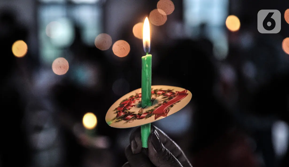 Jemaat HKBP Filadelfia menyalakan lilin saat ibadah malam Natal di Gedung Serbaguna Mandiri Sejahtra CBL, Desa Sumber Jaya, Tambun, Bekasi, Jawa Barat, Kamis (24/12/2020). Keterbatasan dan pandemi COVID-19 tak menyurutkan niat ibadah jemaat HKBP Filadelfia. (merdeka.com/Iqbal S. Nugroho)