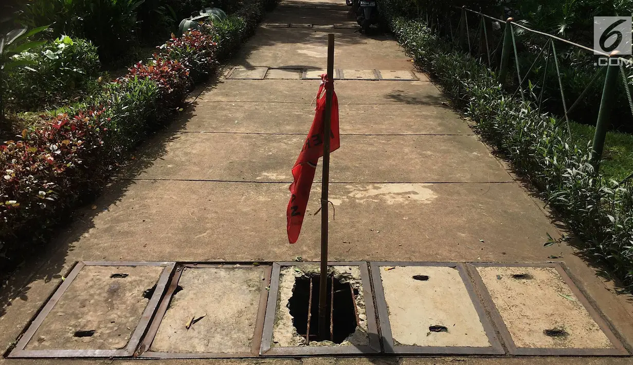 Penampakan trotoar yang rusak dan berlubang di Jalan Kyai Tapa, Jakarta, Kamis (24/1). Banyaknya lubang akibat kerusakan penutup saluran air tersebut membahayakan pejalan kaki. (Liputan6.com/Immanuel Antonius)