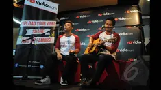 Pemenang ketiga dan kedua Music Video Contest, Eros Tjokro  (kiri) dan Dibya Dika (kanan) saat berduet di kantor Vidio.com, SCTV Tower, Jakarta, Rabu (28/1/2015). (Liputan6.com/Herman Zakharia)