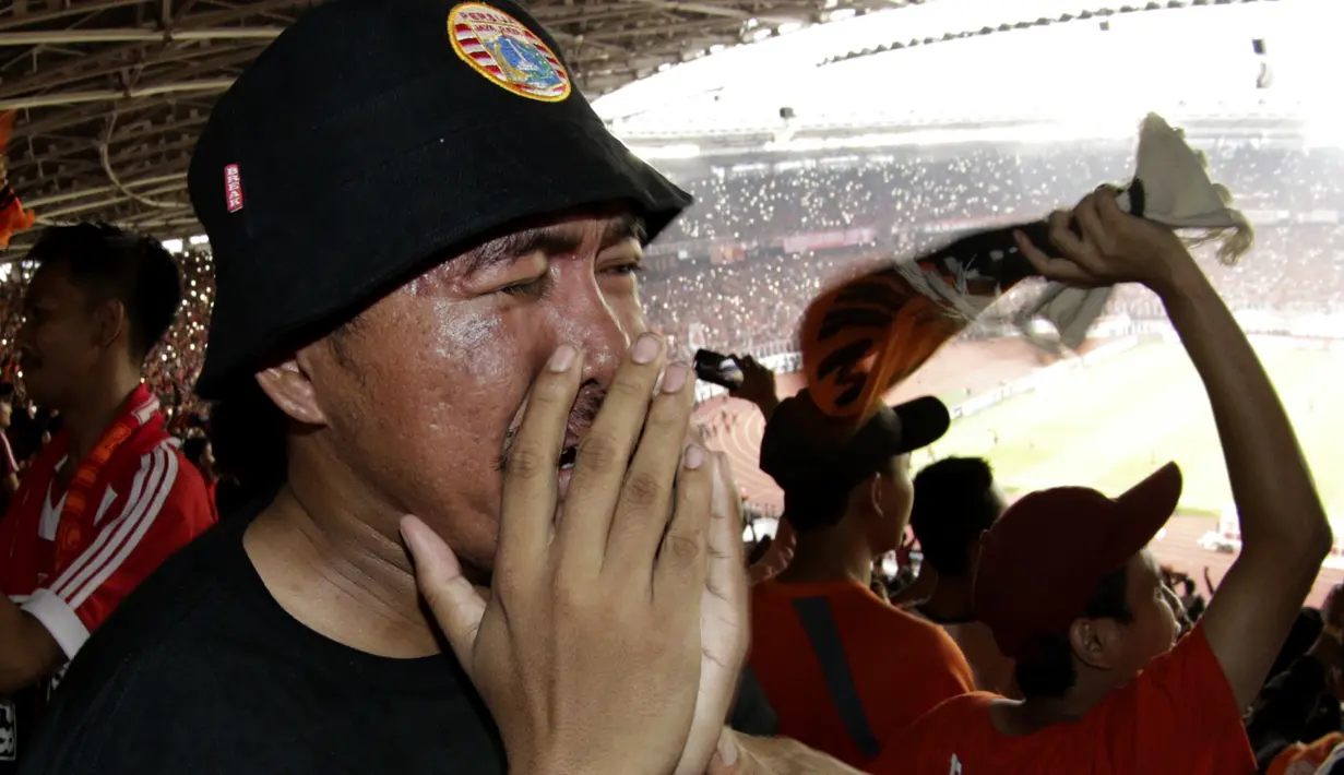 Suporter Persija Jakarta menangis saat merayakan gelar juara Liga 1 di SUGBK, Jakarta, Minggu (09/12). Persija menang 2-1 atas Mitra Kukar. (Bola.com/M Iqbal Ichsan)