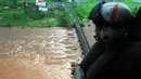 Anggota pasukan pertahanan India terlihat dari helikopter di lokasi jembatan utama yang runtuh akibat derasnya aliran sungai Savitri yang sedang meluap di barat India, Rabu (3/8). Dua bus yang membawa sedikitnya 22 penumpang terjun ke sungai itu. (AFP)