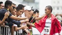 Pelari Indonesia, Agus Prayogo, menyapa suporter usai tampil pada nomor marathon SEA Games di Putrajaya, Kuala Lumpur, Sabtu (19/8/2017). Agus meraih medali perak dengan waktu dua jam 27 menit 16 detik. (Bola.com/Vitalis Yogi Trisna)