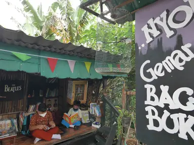 Anak-anak membaca buku di pustaka mini Bale Buku, Kramat Jati, Jakarta Timur, Kamis (20/01/2022). Bale buku yang diresmikan pada Sabtu (15/1) dibangun dari barang-barang bekas oleh komunitas Baca Bale Buku. (Liputan6.com/Herman Zakharia)