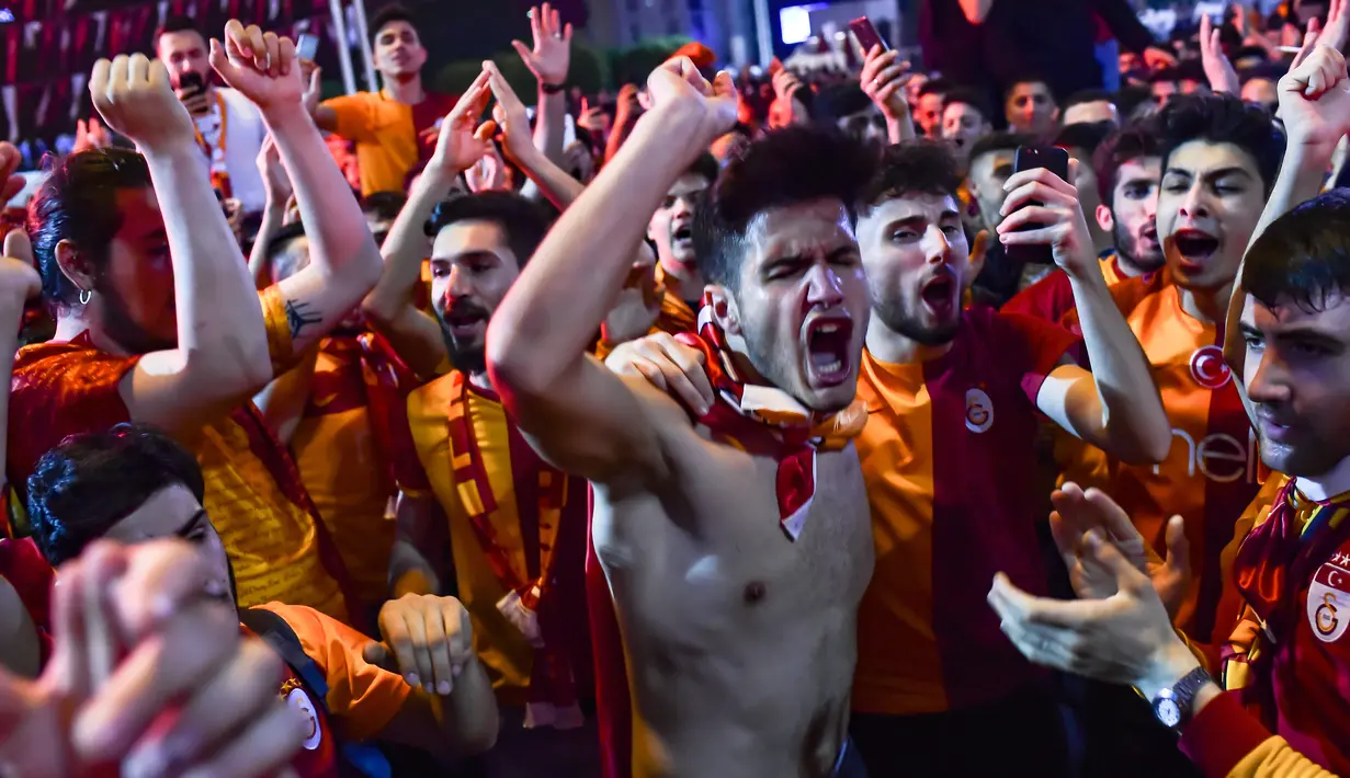 Suporter Galatasaray merayakan kemenangan timnya meraih gelar Liga Turki usai pertandingan melawan Istanbul Basaksehir di Turk Telekom Arena di Istanbul (19/5/2019). Galatasaray memastikan gelar liga Turki ke-22 usai mengalahkan Istanbul Basaksehir 2-1. (AFP Photo/Yasin Akgul)