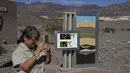 Orang-orang mengunjungi termometer di Pusat Pengunjung Furnace Creek, di Taman Nasional Death Valley, California, Kamis (1/9/2022). Termometer ini tidak resmi tetapi merupakan tempat foto yang populer. (AP Photo/John Locher)