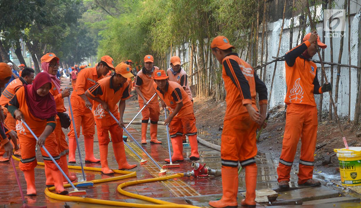 Petugas PPSU membersihkan trotoar di Jalan Asia Afrika, Jakarta, Kamis (2/8). Trotoar yang di pakai para pedagang kaki lima ini di bersihkan guna jelang Asian Games 2018 di Jakarta dan Palembang. (Merdeka.com/Imam Buhori)