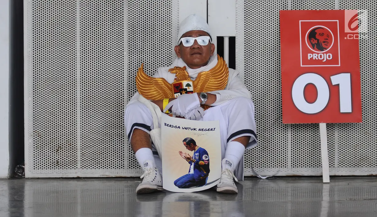 Pendukung capres dan cawapres Joko Widodo (Jokowi)-Ma'ruf Amin memegang poster dan simbol Garuda Pancasila pada kampanye di Stadion Utama GBK, Senayan, Jakarta, Sabtu (13/15). Kampanye diisi dengan konser musik dari ratusan selebritas bertajuk Konser Putih Bersatu. (Liputan6.com/Herman Zakharia)