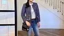 Sandra Dewi mengenakan kaus putih yang ditumpuknya dengan tweed blazer bernuansa biru. Dipadunya penampilan ini dengan belt hitam dan celana jeans. Foto: Instagram.