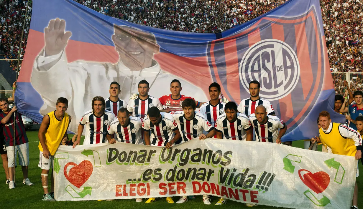 Klub San Lorenzo berfoto bersama dengan latar belakang Banner bergambar Paus Fransiskus sebelum pertandingan melawan Newell Old Boys di Buenos Aires pada 31 Maret 2013. (AFP/NA/Damian Dopacio)