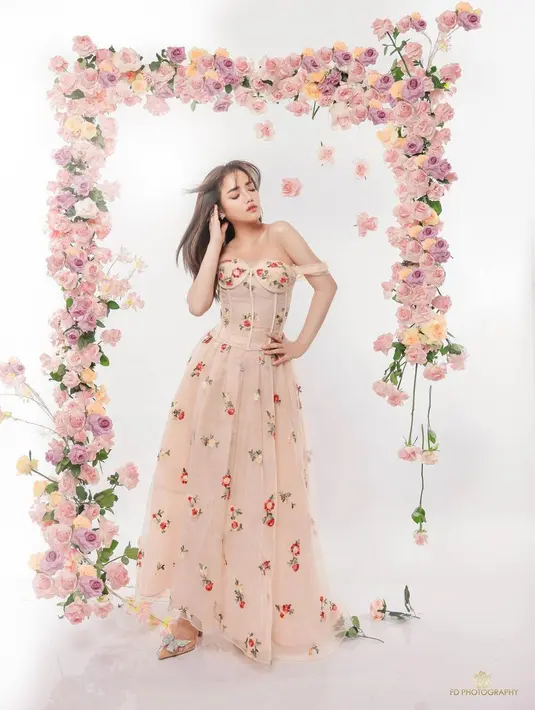 Fuji Utami kenakan gaun bustier dengan rok panjang bermotif bunga. Gaun ini memiliki aksen sabrina yang manis [@fuji_an]