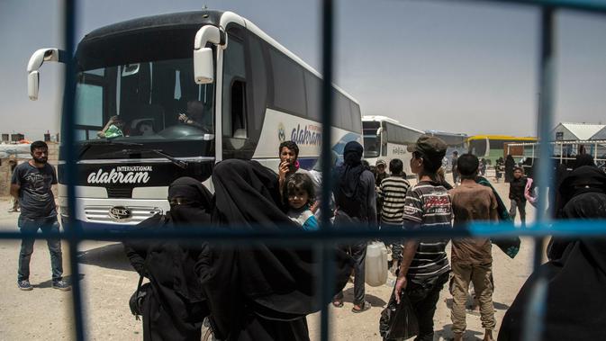 Perempuan dan anak-anak keluarga militan ISIS bersiap meninggalkan kamp penampungan al-Hol di Provinsi Hasakeh, Suriah, Senin (3/6/2019). Para perempuan dan anak-anak dibebaskan menggunakan bus dan truk. (AP Photo/Baderkhan Ahmad)