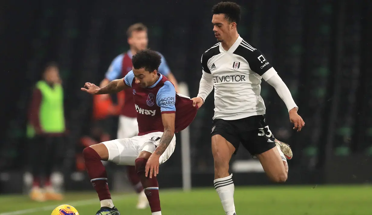 Gelandang West Ham United, Jesse Lingard (kiri) menguasai bola dibayangi bek Fulham, Antonee Robinson dalam laga lanjutan Liga Inggris 2020/21 pekan ke-23 di Craven Cottage, Sabtu (6/2/2021). West Ham United bermain imbang 0-0 dengan Fulham. (AFP/Adam Davy/Pool)