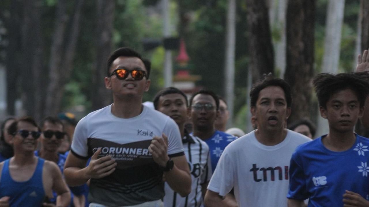 Peserta maraton TMII Running Club berlari melewati lintasan pada Taman Mini Indonesia Indah (TMII), Jakarta, Jumat (20/9/2024). Foto: Merdeka.com/Imam Buhori