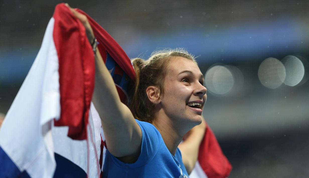Sara Kolak saat merayakan kemenangannya dengan berlari sambil mengibarkan bendera Kroasia di Stadion Olympic, (19/8/2016). (AFP/Johannes Eisele)
