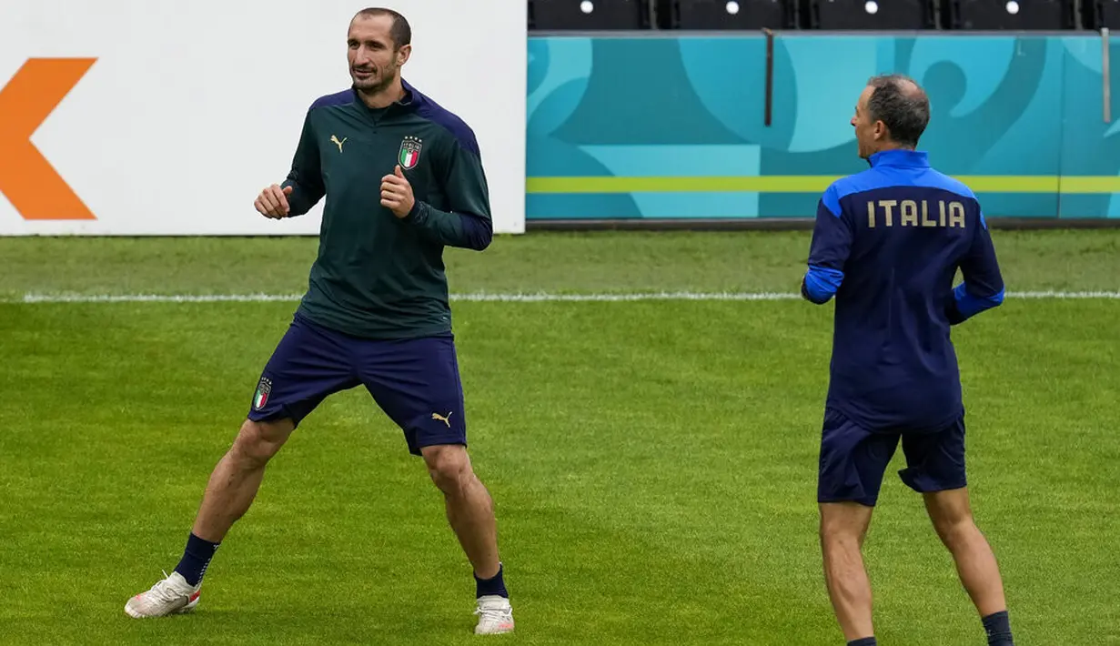 Bek Italia, Giorgio Chiellini (kiri) melakukan pemanasan selama sesi latihan di stadion Hive di London, Inggris, Senin (5/7/2021). Italia akan menghadapi Spanyol pada babak semifinal Euro 2020  di Stadion Wembley, Inggris. (AP/Matt Dunham)