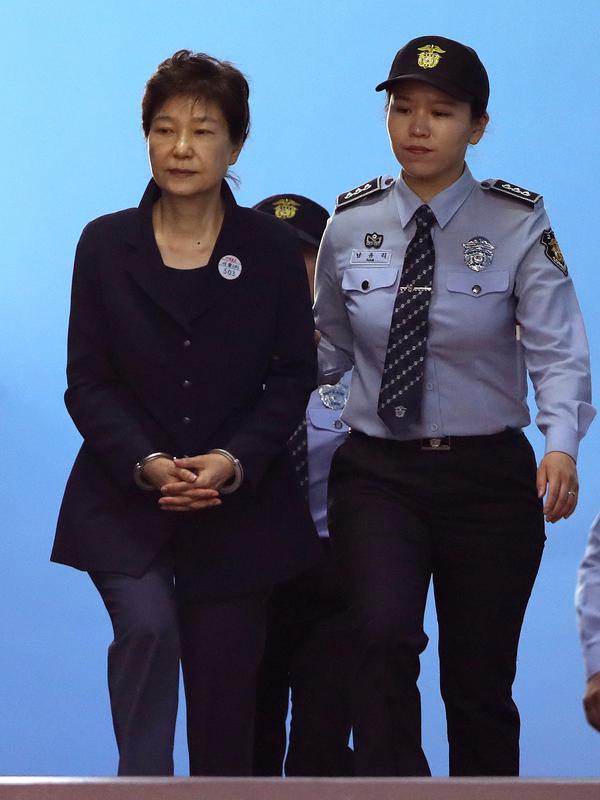 Mantan Presiden Korsel Park Geun-hye  dikawal petugas lembaga pemasyarakatan tiba Pengadilan Distrik Pusat Seoul, Korea Selatan (23/5). Sidang dipimpin oleh hakim utama Kim Se-yun. (AP Photo/Lee Jin-man)