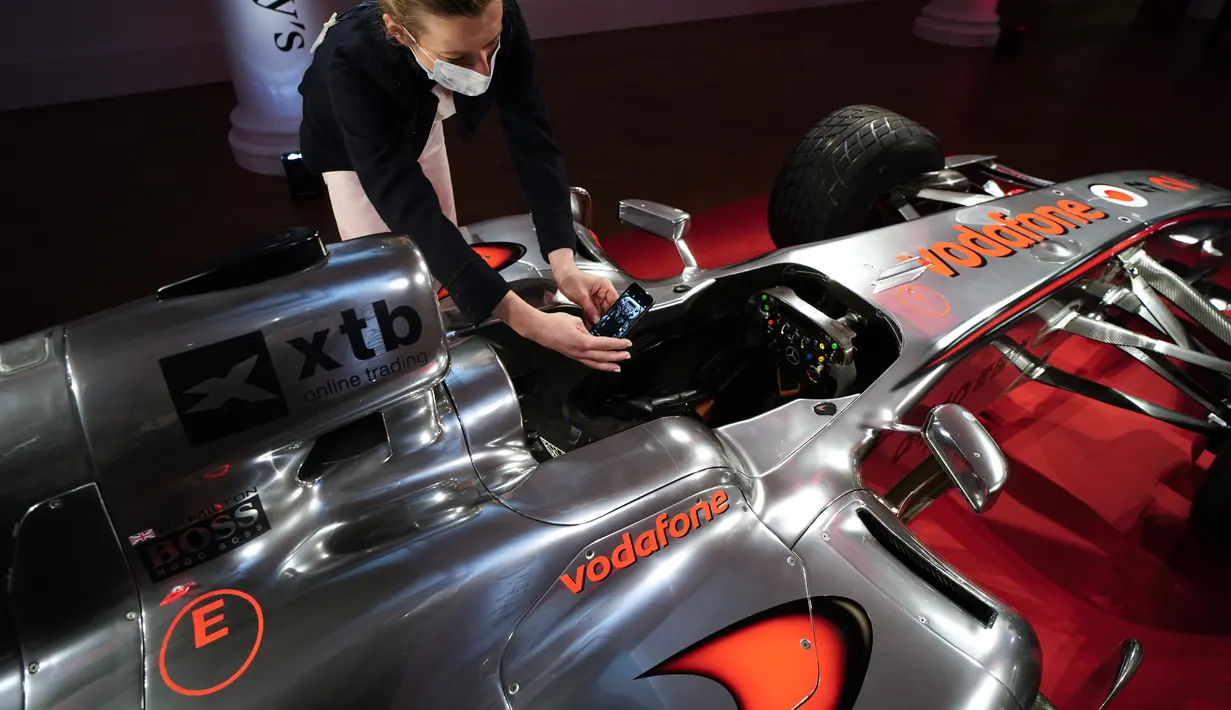 Staf memfoto mobil McLaren MP4-25A Mercedes yang dikendarai Lewis Hamilton pada GP Turki 2010, di Sotheby London, Selasa (18/5/2021). Mobil yang pernah membawa Hamilton menjadi juara dunia pada 2010 itu diperkirakan akan laku sekitar Rp 71,5 miliar hingga Rp 100 miliar. (AP Photo/Alberto Pezzali)