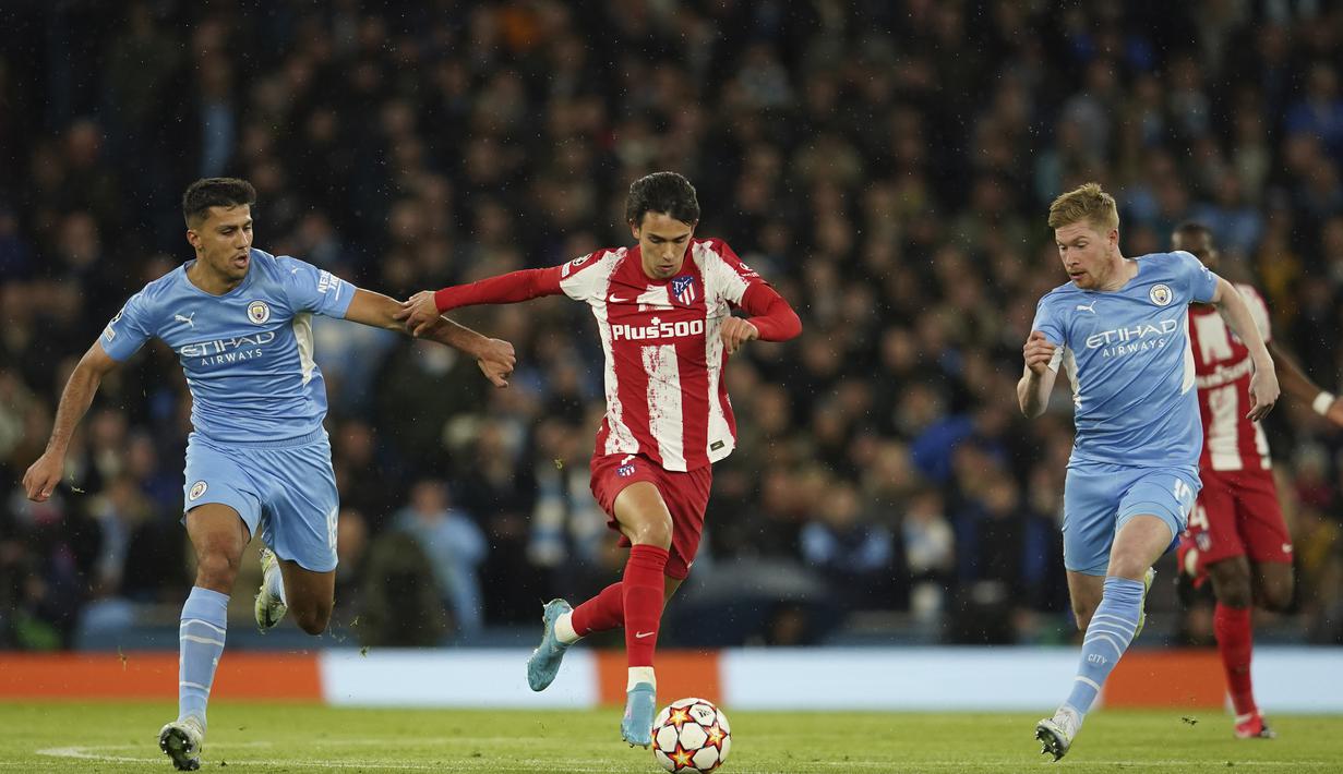 Gelandang Atletico Madrid, Joao Felix (tengah) membawa bola dari kejaran pemain Manchester City, Rodrigo dan Kevin De Bruyne pada pertandingan leg pertama perempat final Liga Champions di Stadion Etihad, di Manchester, Rabu (6/4/2022). City menang tipis atas Atletico Madrid 1-0. (AP Photo/Dave Thomp