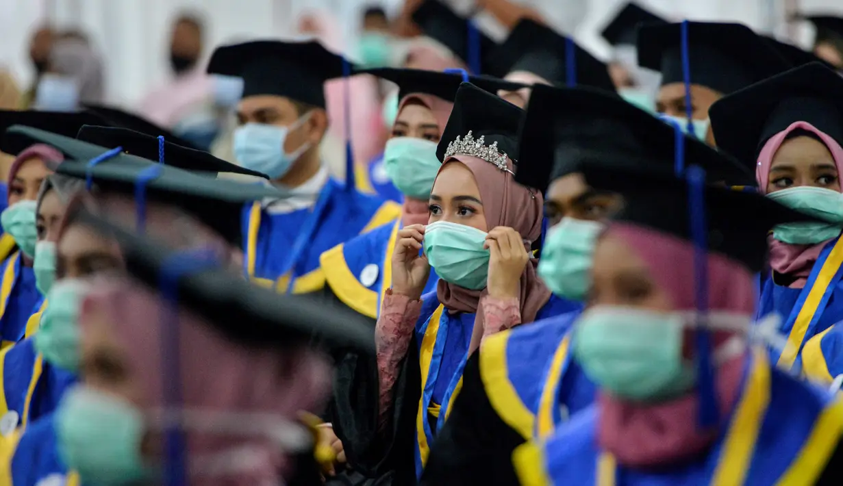 Sejumlah pelajar yang memakai masker sebagai tindakan pencegahan terhadap virus corona COVID-19 mengikuti acara wisuda SMK Farmasi di Banda Aceh (24/9/2020). (AFP/Chaideer Mahyuddin)