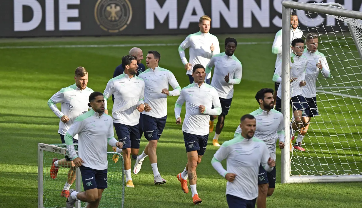 Para pemain Swiss melakukan pemanasan saat mengikuti sesi latihan tim di Stadion RheinEnergie, Cologne, Jerman (12/10/2020). Swiss akan bertanding melawan Jerman dalam lanjutan UEFA Nations League Divisi A Grup 4 (A4). (AP Photo/Martin Meissner)