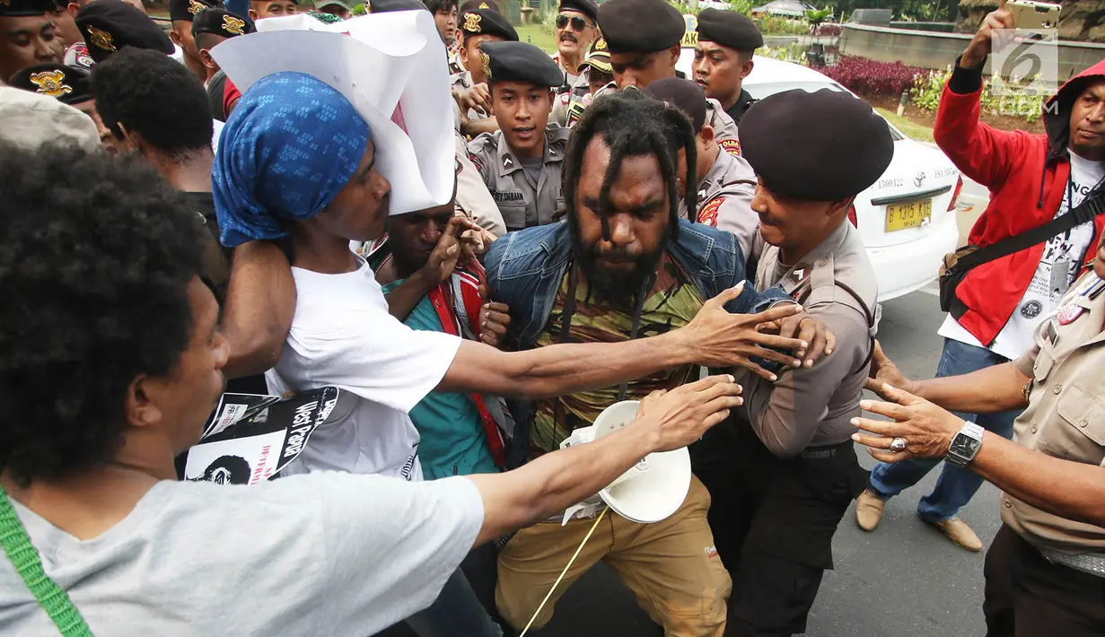Massa yang tergabung dalam Front Rakyat Indonesia untuk West Papua (FRI-WP) dan Aliansi Mahasiswa Papua (AMP) terlibat aksi saling dorong dengan polisi saat unjuk rasa di Jalan Medan Merdeka Barat, Jakarta, Selasa (15/8). (Liputan6.com/Immanuel Antonius)