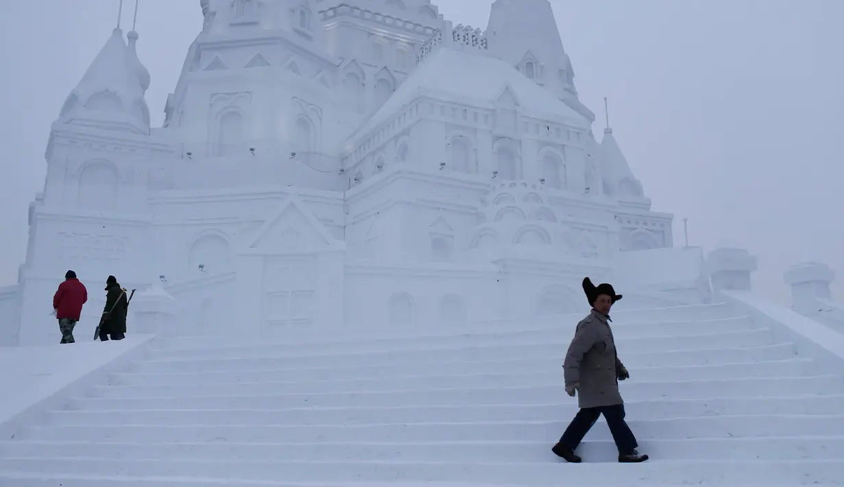 Pengunjung berjalan ditangga sebuah bangunan yang terbuat dari es di kota utara Harbin, provinsi Heilongjiang , Cina, (5/1). Bangunan es yang dibuat menyerupai Istana dengan ukuran yang besar. (REUTERS/Aly Song)
