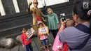 Pengunjung berpose dengan manusia patung di kawasan Museum Fatahilah, Kota Tua, Jakarta, Jumat (16/2). Libur Imlek 2018 dimanfaatkan warga untuk berwisata di sejumlah lokasi, Salah satu yang ramai dikunjungi yakni Kota Tua (Liputan6.com/Immanuel Antonius)