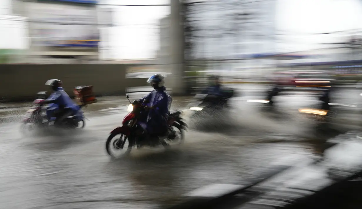 Pengendara sepeda motor melintasi jalan yang banjir akibat badai tropis parah Conson di kota Quezon, Filipina (8/9/2021).  Topan Conson juga mengakibatkan banjir di beberapa daerah. (AP Photo/Aaron Favila)