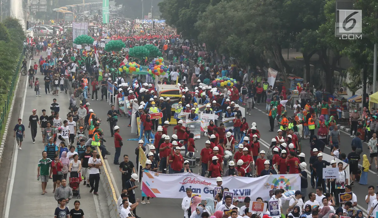 Ribuan peserta Parade Asian Games 2018 melintasi Jalan MH Thamrin, Jakarta, Minggu (15/5). Kegiatan Parade Asian Games yang ke 18 di buka oleh Wakil Presiden Republik Indonesia Muhammad Yusuf Kalla. (Liputan6.com/Arya Manggala)