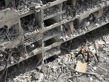 Perwira komando garis depan Israel meninjau lokasi serangan rudal langsung yang diluncurkan dari Iran di Tel Aviv, Minggu 22 Juni 2025. (AP/Oded Balilty)