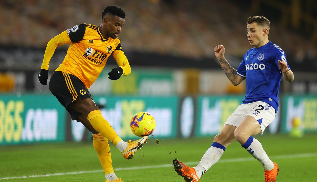 Bek Wolverhampton Wanderers, Nelson Semedo (kiri) mengontrol bola di depan bek Everton, Lucas Digne dalam laga lanjutan Liga Inggris 2020/21 di Molineux Stadium, Selasa (12/1/2021). Wolverhampton Wanderers kalah 1-2 dari Everton. (AFP/Richard Heathcote/Pool)
