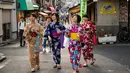 Sejumlah wanita memakai pakaian tradisional berjalan di sepanjang jalan perbelanjaan Yanaka Ginza di pusat Tokyo (30/9/2019). Bagian kota yang sudah tua ini terhindar dari pengeboman Sekutu selama Perang Dunia II dan selamat dari Gempa Besar Kanto dan Kebakaran tahun 1923. (AFP Photo/Odd Andersen)