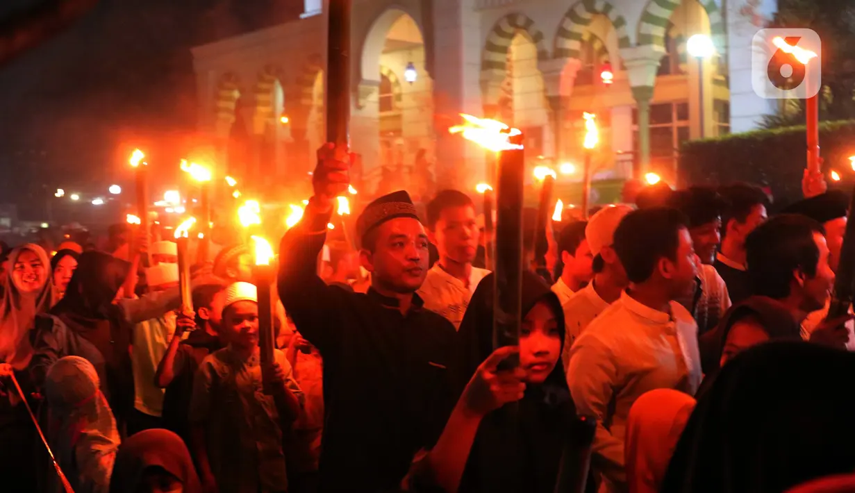 Anak-anak membawa obor sambil berkeliling kampung di kawasan Kota Tangerang, Banten, Jumat (29/7/2022) malam. Pawai obor tersebut digelar untuk menyambut malam pergantian Tahun Baru Islam atau 1 Muharam 1444 H. (Liputan6.com/Angga Yuniar)