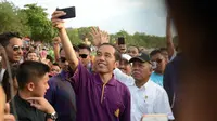 Presiden Jokowi memegang kamera dan selfie bersama para wisatawan di Pantai Kuta, Bali, Jumat (22/12/2017) (Liputan6.com/Pool/Lifestyle)