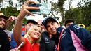 Pembalap F1 Racing Point, Sergio Perez berselfie dengan penggemarnya saat tiba di Sirkuit Melbourne Grand Prix di Melbourne, Jumat (15/3). Seri GP Australia akan menjadi pembuka ajang Formula 1 (F1) musim 2019. (Reuters/Edgar Su)