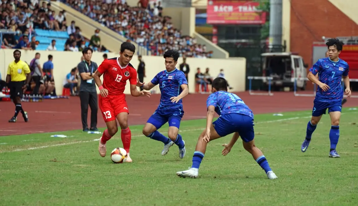 Pemain Timnas Indonesia U-23 Rachmat Irianto (kiri) menggiring bola melewati para pemain Timnas Thailand U-23 pada pertandingan semifinal SEA Games 2021 di Thien Truong Stadium, Vietnam, Kamis (19/5/2022). Timnas Indonesia U-23 kalah 0-1. (Dok. PSSI)