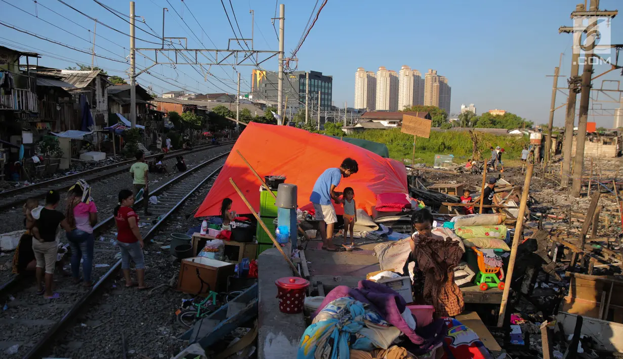 Aktivitas warga korban kebakaran Kampung Bandan, Jakarta, Senin (18/9). Hari kedua pasca kebakaran warga masih bertahan di lokasi bekas kebakaran dengan membangun tenda seadanya. (Liputan6.com/Faizal Fanani)