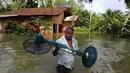 Seorang warga menyelamatkan barang-barangnya dari banjir di Sri Lanka, Minggu (28/5). Atas bencana banjir dan longsor ini, Kementerian Luar Negeri Sri Lanka telah mengajukan permintaan bantuan dari PBB dan negara-negara tetangga. (AP Photo)