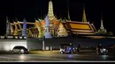 Foto kombinasi menunjukkan Grand Palace sebelum (atas) dan setelah (bawah) lampunya dimatikan untuk menandai kampanye lingkungan Earth Hour di Bangkok (27/3/2021). (AFP/Mladen Antonov)