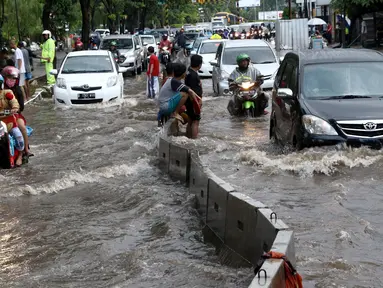 Sejumlah kendaraan nekat menerobos banjir di depan Mall Gandaria City, Jakarta, Sabtu (27/8). Hujan deras di wilayah Jabodetabek membuat jalan tersebut banjir setinggi 30-50 cm. (Liputan6.com/Helmi Afandi)