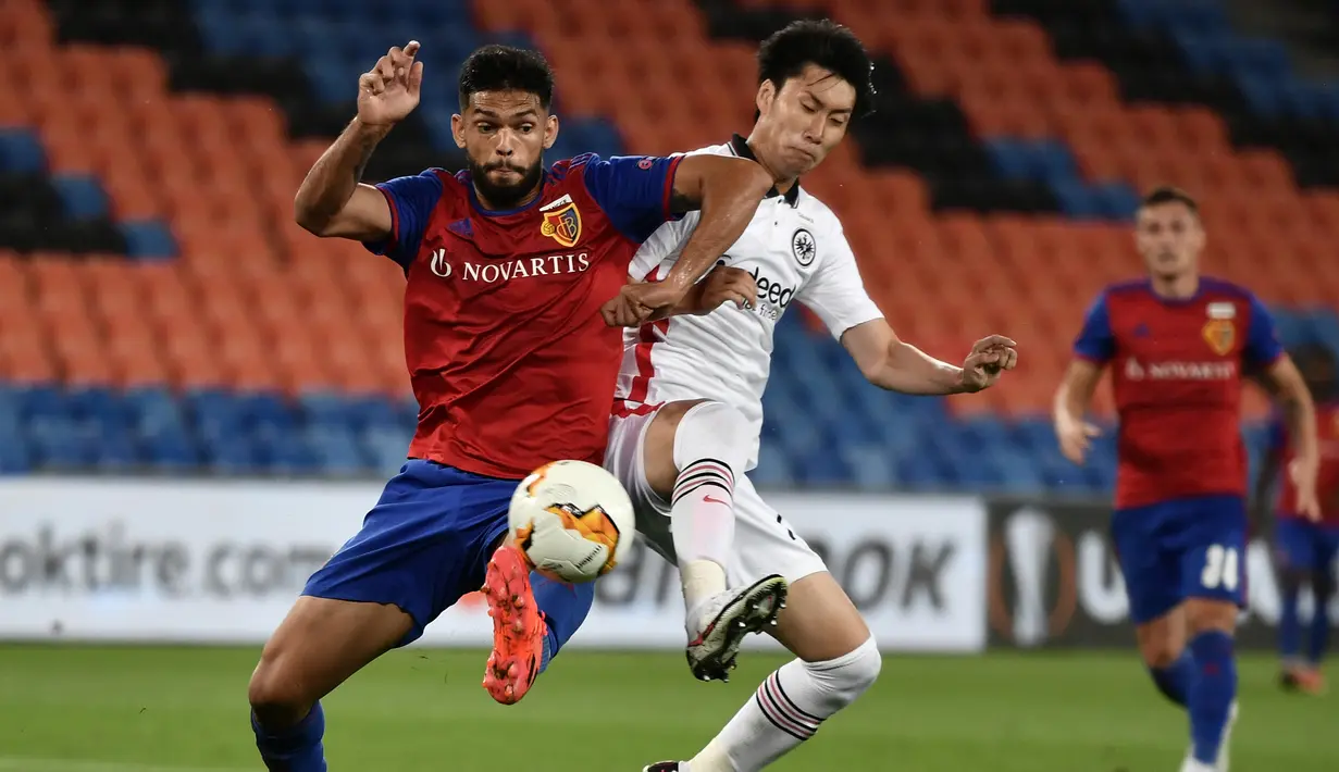 Bek Basel, Eray Comert, berebut bola dengan gelandang Eintracht Frankfurt, Daichi Kamada, dalam laga babak 16 besar Liga Europa 2019/2020 di St.Jakob Park, Basel, Jumat (7/8/2020) dini hari WIB. Basel menang 1-0 atas Eintracht Frankfurt. (AFP/Fabrice Coffrini)