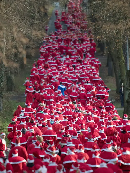 Para peserta mengenakan kostum Santa Claus berpartisipasi dalam Santa Claus Run di Michendorf, Jerman timur, Minggu (10/12). Kegiatan amal yang digelar setiap tahun ini diikuti ribuan warga Jerman dan wisatawan mancanegara. (Ralf Hirschberger/dpa via AP)