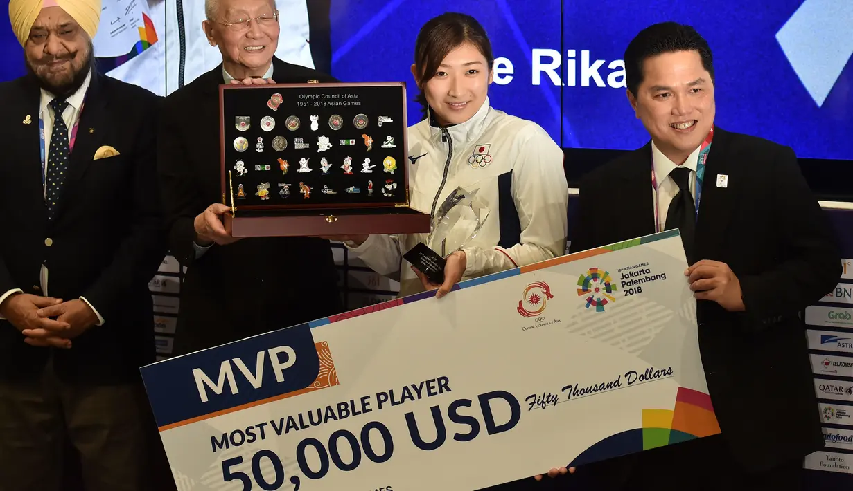 Perenang Jepang Rikako Ikee (dua kanan) didampingi Ketua Inasgoc Erick Thohir (kanan) saat penyerahan hadiah 50.000 USD sebagai Most Valuable Player (MVP) Asian Games 2018 di Jakarta, Minggu (2/9). (Arief Bagus/AFP)